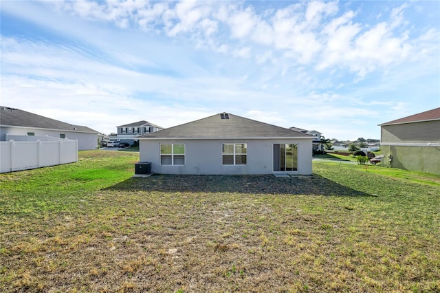 rear view of property featuring a yard and central AC