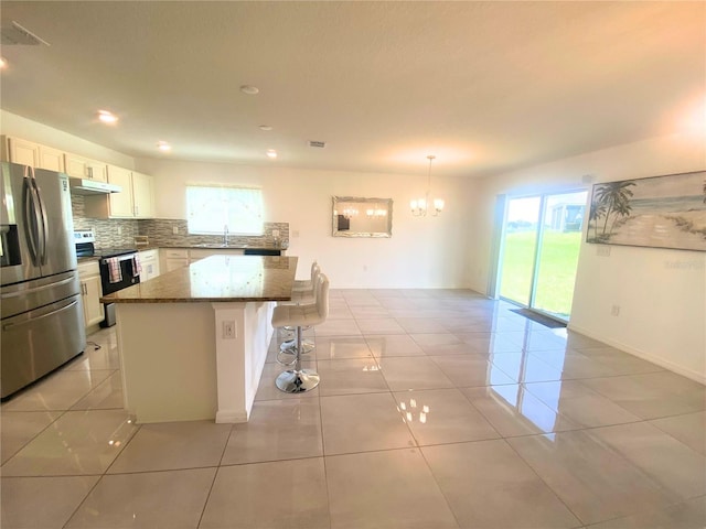 kitchen featuring stainless steel appliances, white cabinetry, a wealth of natural light, and a center island