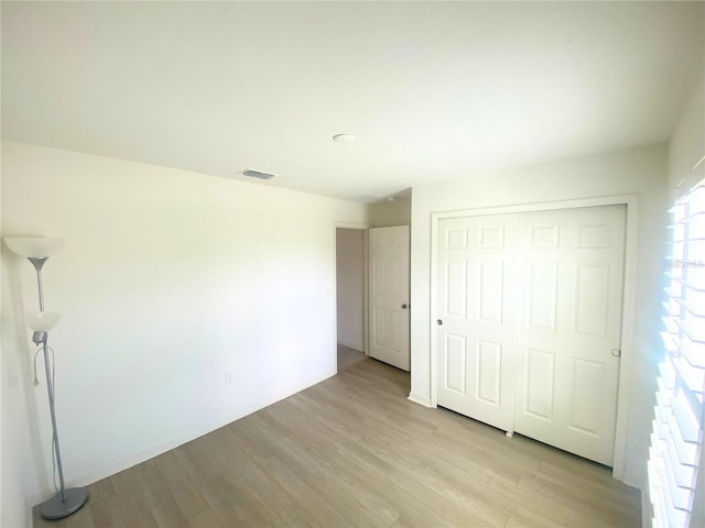 unfurnished bedroom with light hardwood / wood-style floors and a closet