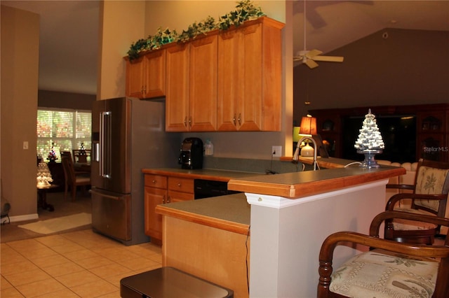 kitchen with kitchen peninsula, high end refrigerator, ceiling fan, light tile flooring, and lofted ceiling