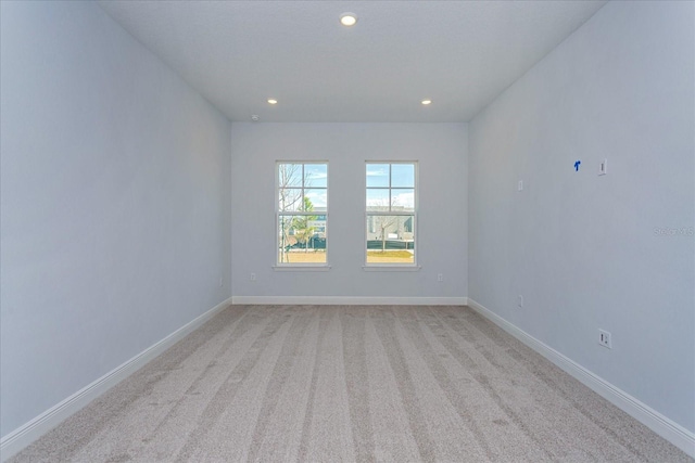 spare room featuring light colored carpet