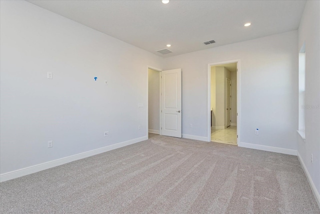 unfurnished bedroom with ensuite bath and light carpet