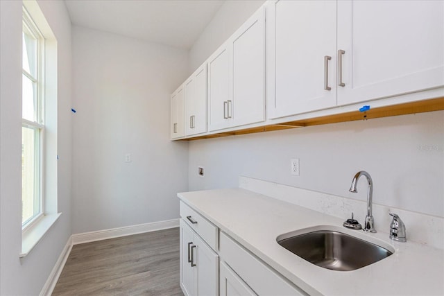 kitchen featuring white cabinetry, sink, and light hardwood / wood-style floors