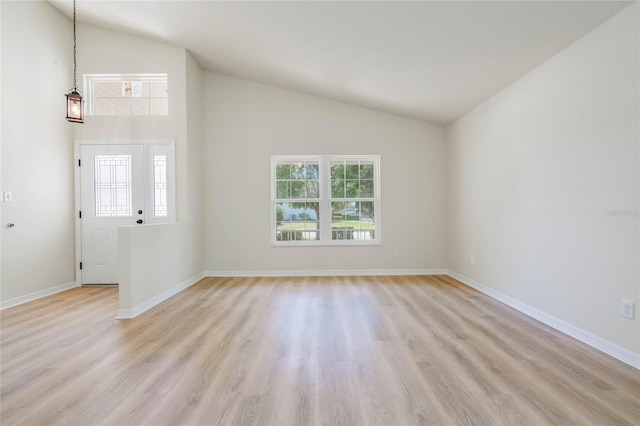 unfurnished room with high vaulted ceiling and light wood-type flooring