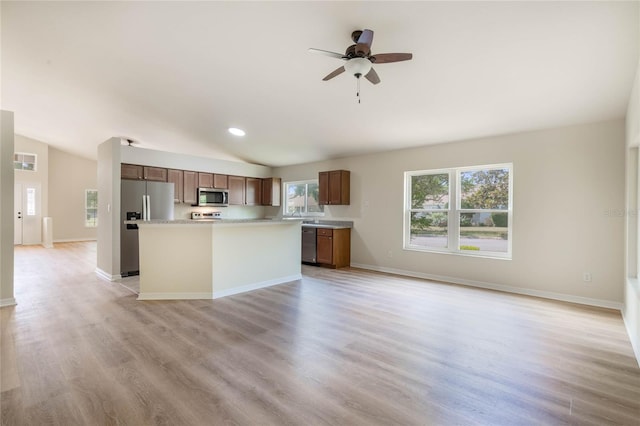 kitchen featuring ceiling fan, lofted ceiling, light hardwood / wood-style flooring, and stainless steel appliances