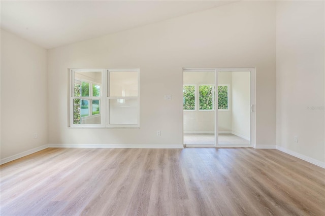 empty room featuring light hardwood / wood-style flooring and lofted ceiling