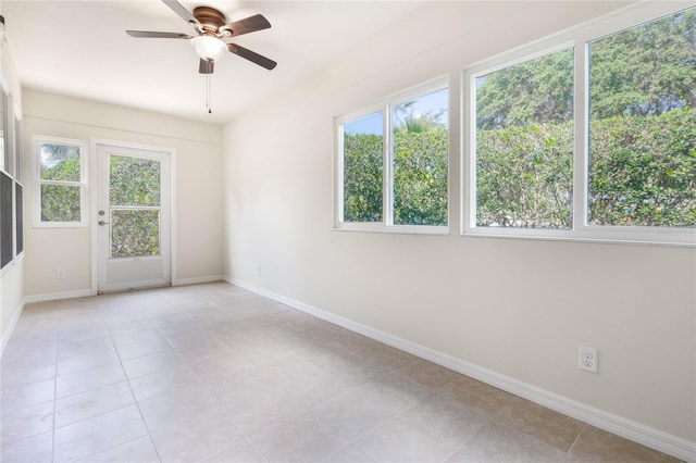 tiled spare room with plenty of natural light and ceiling fan