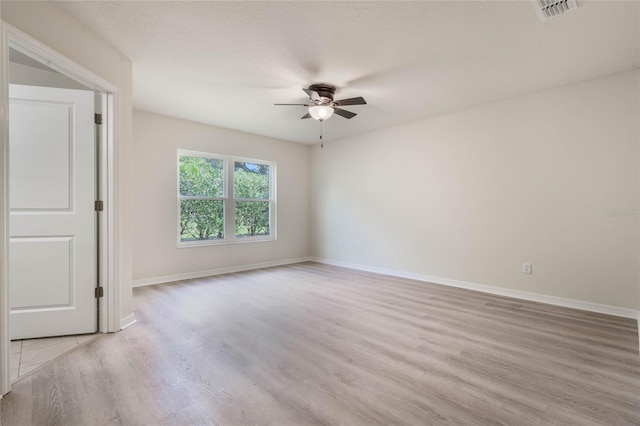 spare room featuring ceiling fan and light hardwood / wood-style floors