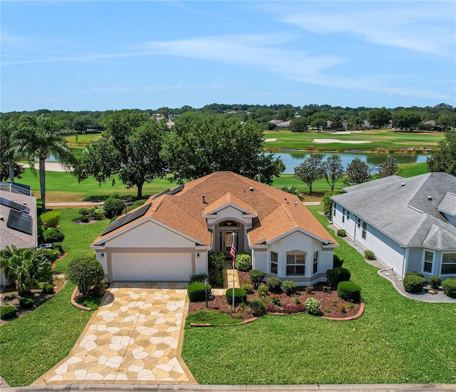 view of front of home featuring a garage, a front yard, and a water view