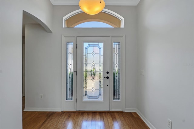 foyer entrance with hardwood / wood-style floors and crown molding