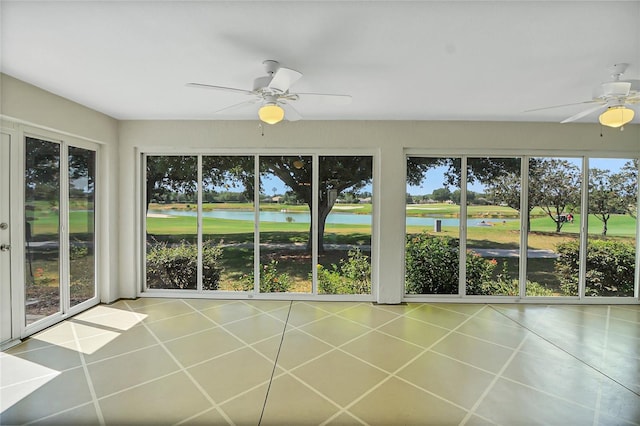 unfurnished sunroom with a water view and ceiling fan