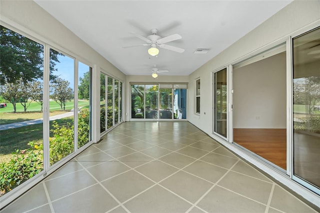 unfurnished sunroom with ceiling fan