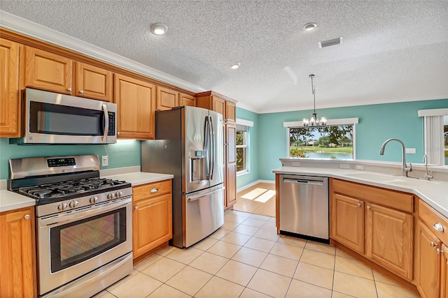 kitchen with sink, light tile floors, stainless steel appliances, and an inviting chandelier