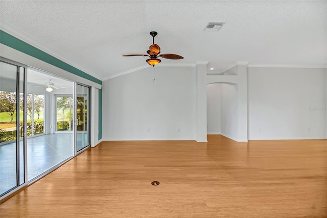 spare room with lofted ceiling, ceiling fan, crown molding, and light wood-type flooring