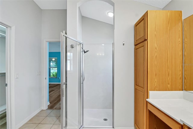 bathroom featuring an enclosed shower, tile flooring, and lofted ceiling