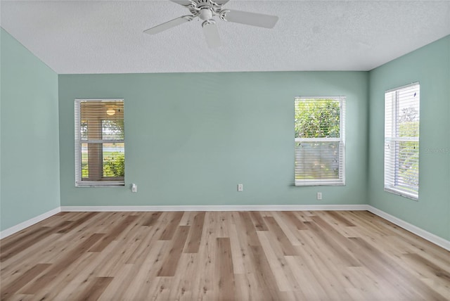 empty room featuring light hardwood / wood-style flooring, ceiling fan, and a textured ceiling