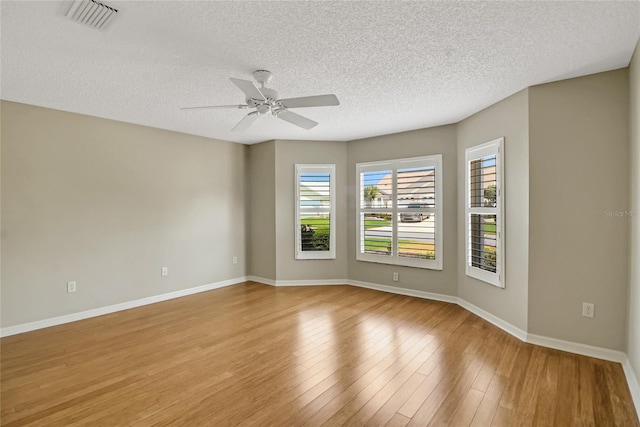 empty room featuring ceiling fan, a textured ceiling, and light wood-type flooring