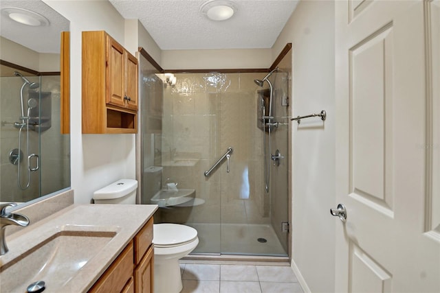 bathroom with large vanity, a textured ceiling, walk in shower, toilet, and tile floors