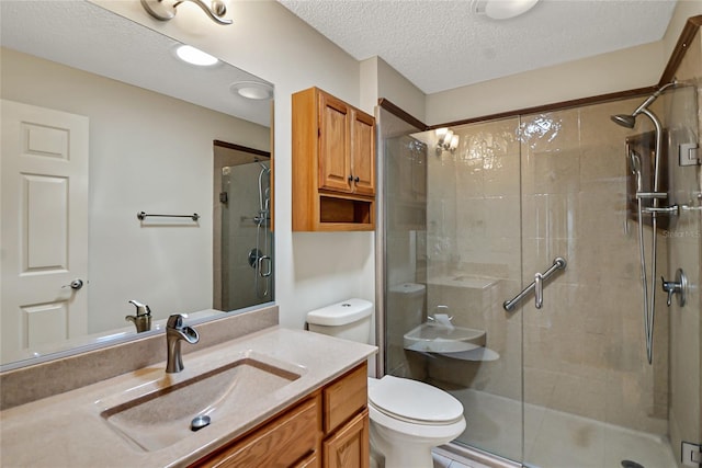 bathroom featuring walk in shower, vanity, toilet, and a textured ceiling