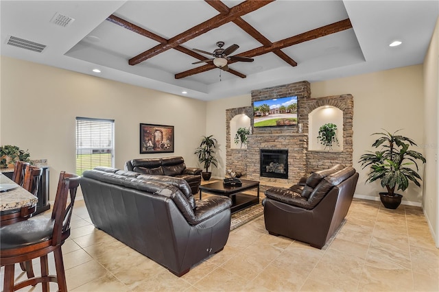 tiled living room with ceiling fan, a stone fireplace, coffered ceiling, a raised ceiling, and beam ceiling