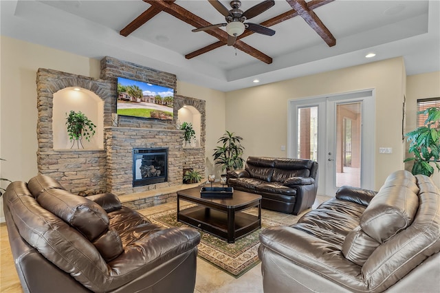 living room featuring ceiling fan, a raised ceiling, a fireplace, and coffered ceiling