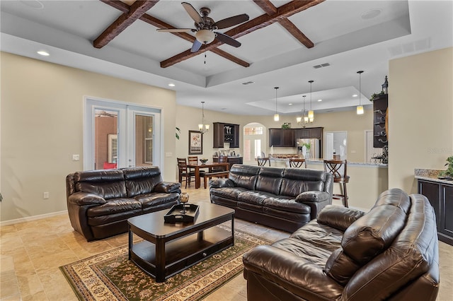 living room with light tile floors, a tray ceiling, and coffered ceiling