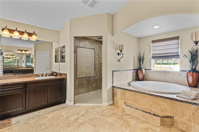 bathroom featuring plus walk in shower, vanity, and tile floors