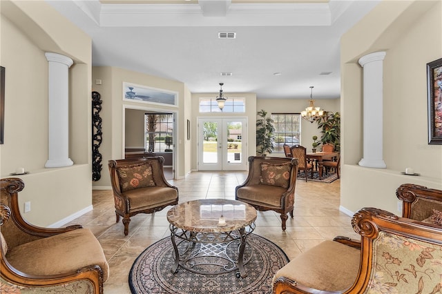 living room with ornate columns, a notable chandelier, and light tile floors