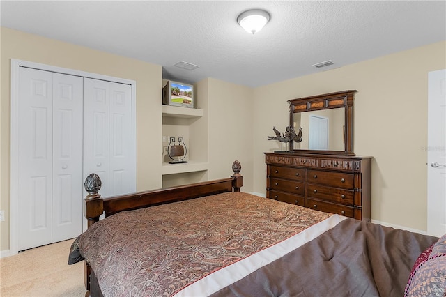 carpeted bedroom featuring a closet and a textured ceiling