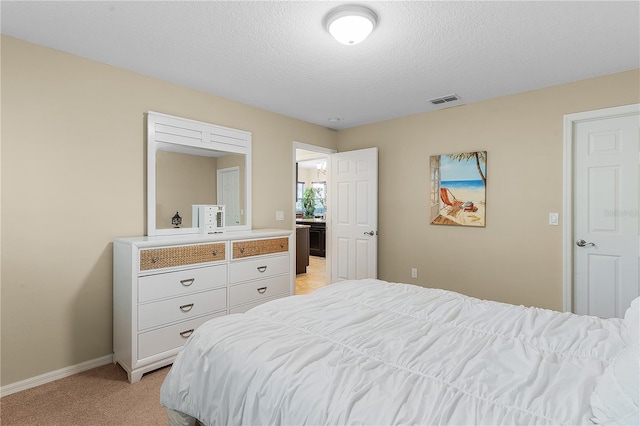 bedroom with a textured ceiling and light carpet