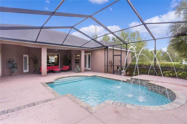 view of swimming pool with a patio area, ceiling fan, pool water feature, and glass enclosure