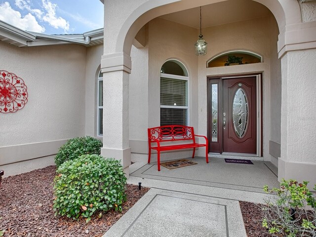 doorway to property featuring stucco siding