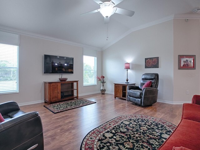 living area with lofted ceiling, ornamental molding, and wood finished floors