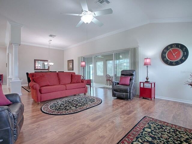 living area featuring visible vents, light wood-style flooring, ornate columns, and ceiling fan with notable chandelier