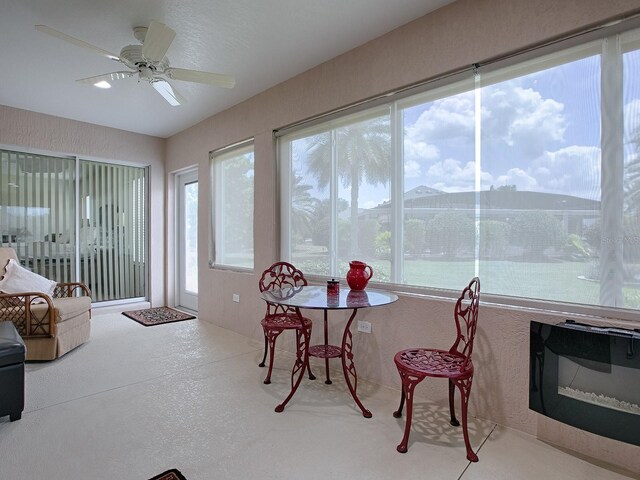 sunroom / solarium featuring ceiling fan and a water and mountain view