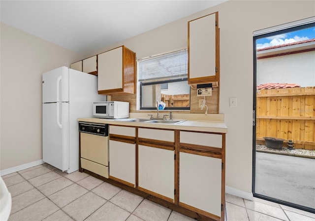 kitchen featuring white appliances, white cabinetry, sink, and light tile patterned floors