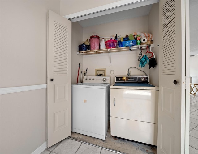 clothes washing area with separate washer and dryer and light tile patterned floors