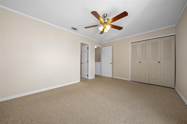 unfurnished bedroom featuring ceiling fan, ornamental molding, and carpet