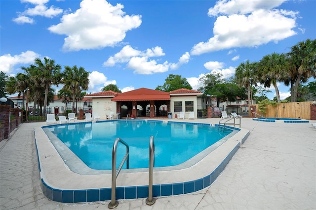 view of swimming pool featuring a community hot tub and a patio