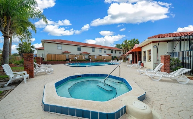 view of pool with a patio and a hot tub