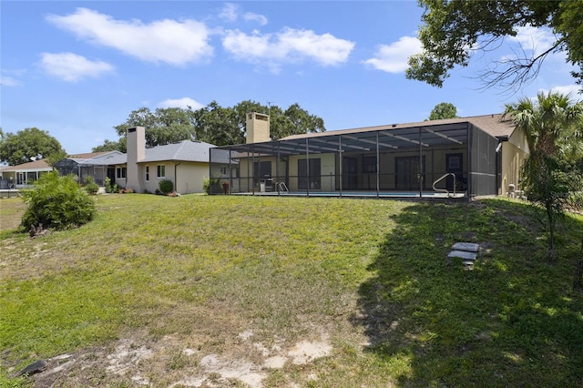 rear view of property featuring glass enclosure and a lawn