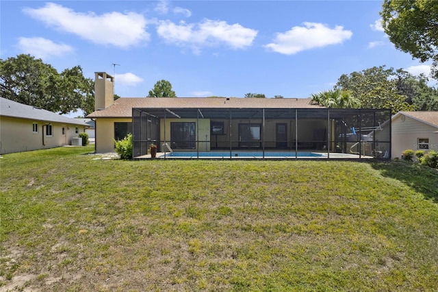 rear view of property featuring a lawn and a lanai