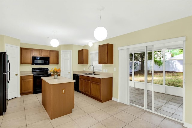 kitchen featuring hanging light fixtures, sink, black appliances, a center island, and light tile patterned floors