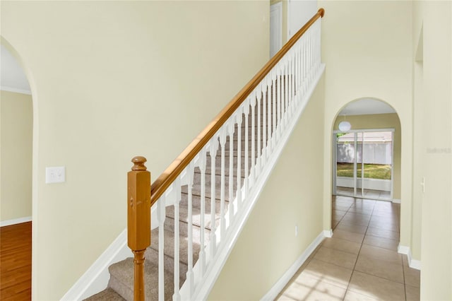 stairs featuring ornamental molding and wood-type flooring