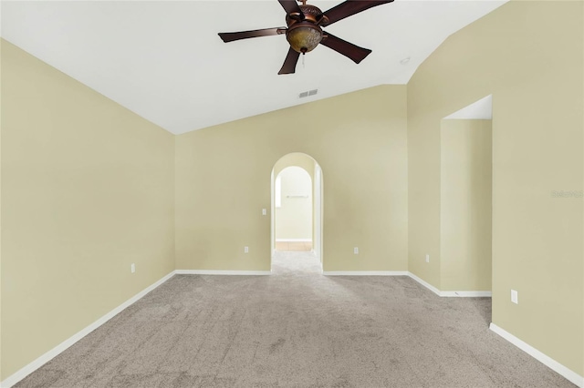 carpeted spare room featuring vaulted ceiling and ceiling fan