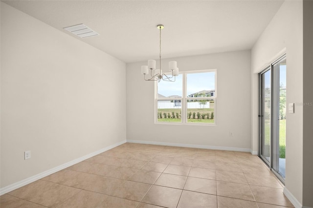 tiled spare room with an inviting chandelier