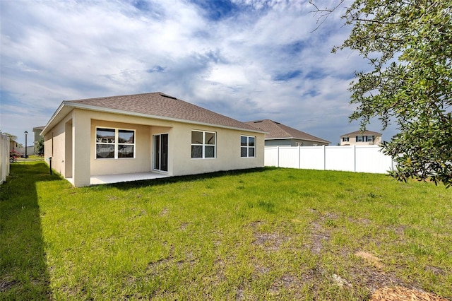 rear view of house featuring a lawn