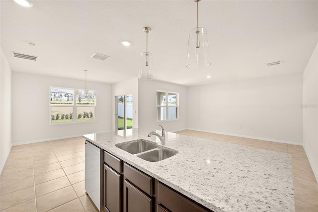 kitchen featuring sink, light tile patterned floors, decorative light fixtures, light stone countertops, and stainless steel dishwasher