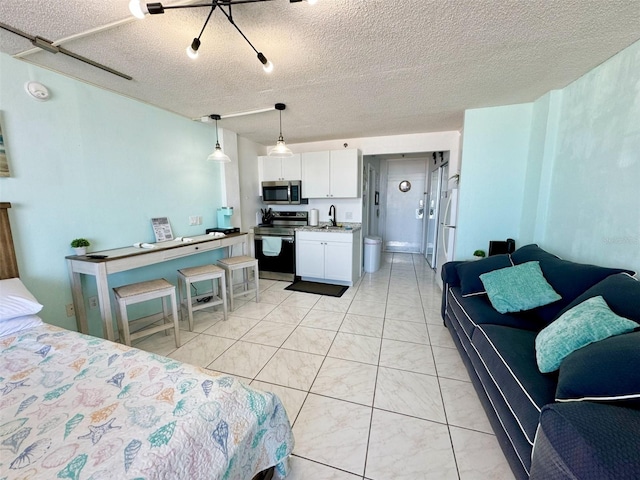 tiled bedroom featuring sink, connected bathroom, and a textured ceiling