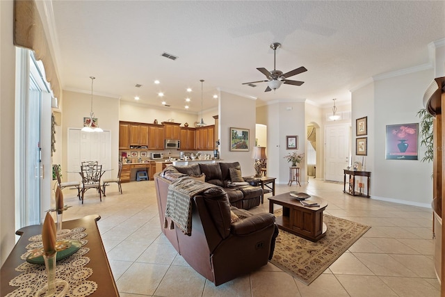 living room with a textured ceiling, ceiling fan, light tile patterned floors, and crown molding